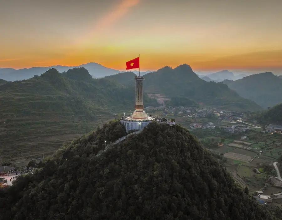 Ha Giang Loops Lung Cu Tower atop the mountain, amidst the vast mountain landscape.